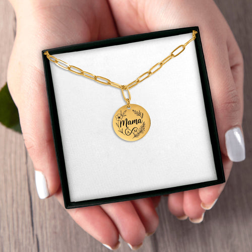 Gold necklace with a circular pendant featuring a star design, held in a hand.