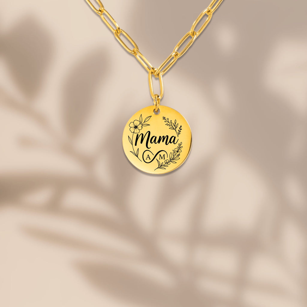 Gold necklace with a round pendant engraved with 'Mama' on a beige background